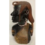 A large African carved dark wood bust with beaded detail.