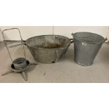 3 vintage galvanised items; a 2 handled bath, a swing handled bucket and a feeder/drinker stand.