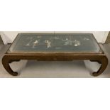 An Oriental wooden coffee table with figural detail made from pieces of natural stone and shell.