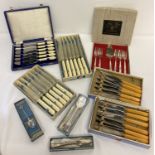 A collection of boxed vintage stainless steel and silver plated cutlery sets.