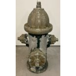 A vintage metal fire hydrant with remnants of original paintwork.