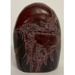 A carved red and black Chinese soapstone seal depicting fishermen.