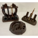 A collection of assorted vintage pipes and pipe rests to include wooden and Bakelite examples.