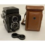 A 1950's Japanese Yashica Flex S Copal twin lens camera with original tan leather carry case.
