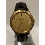 A men's vintage Omega De Ville quartz wristwatch with gold tone case & date function.