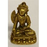 A miniature gilt bronze figure of an Oriental Deity.