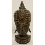 A carved wooden figure of the head of Buddha.