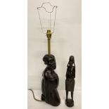 A carved tribal table light base of a mother and child.