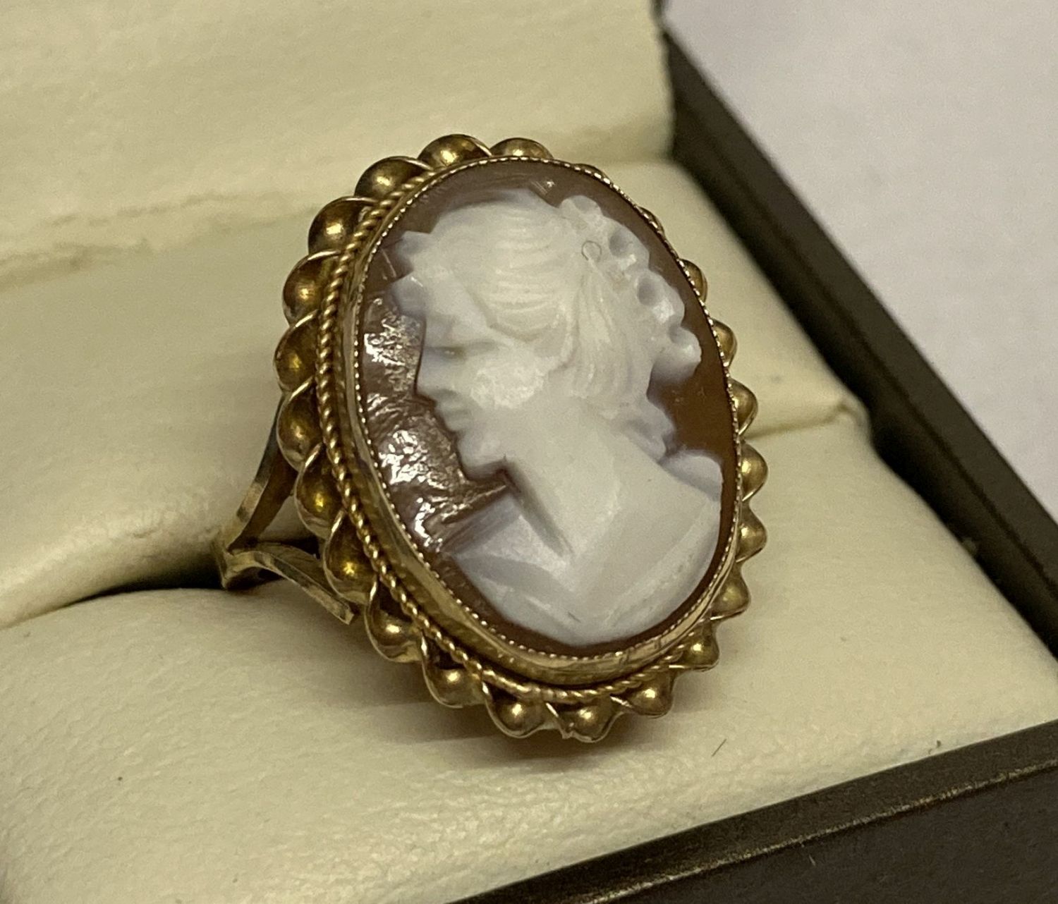 A 9ct yellow gold cameo dress ring. An oval cameo set in gold mount with rope design to outer edge.