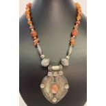 An ethnic style metal and natural carnelian pendant style statement necklace.