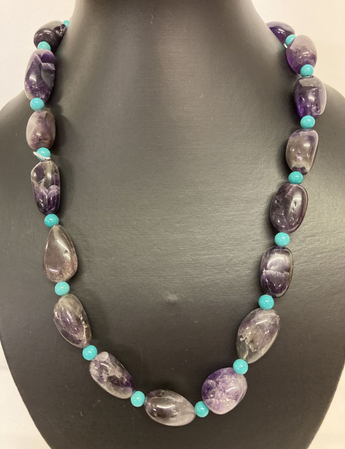 A 20" amethyst and turquoise beaded necklace with white metal S shaped clasp.