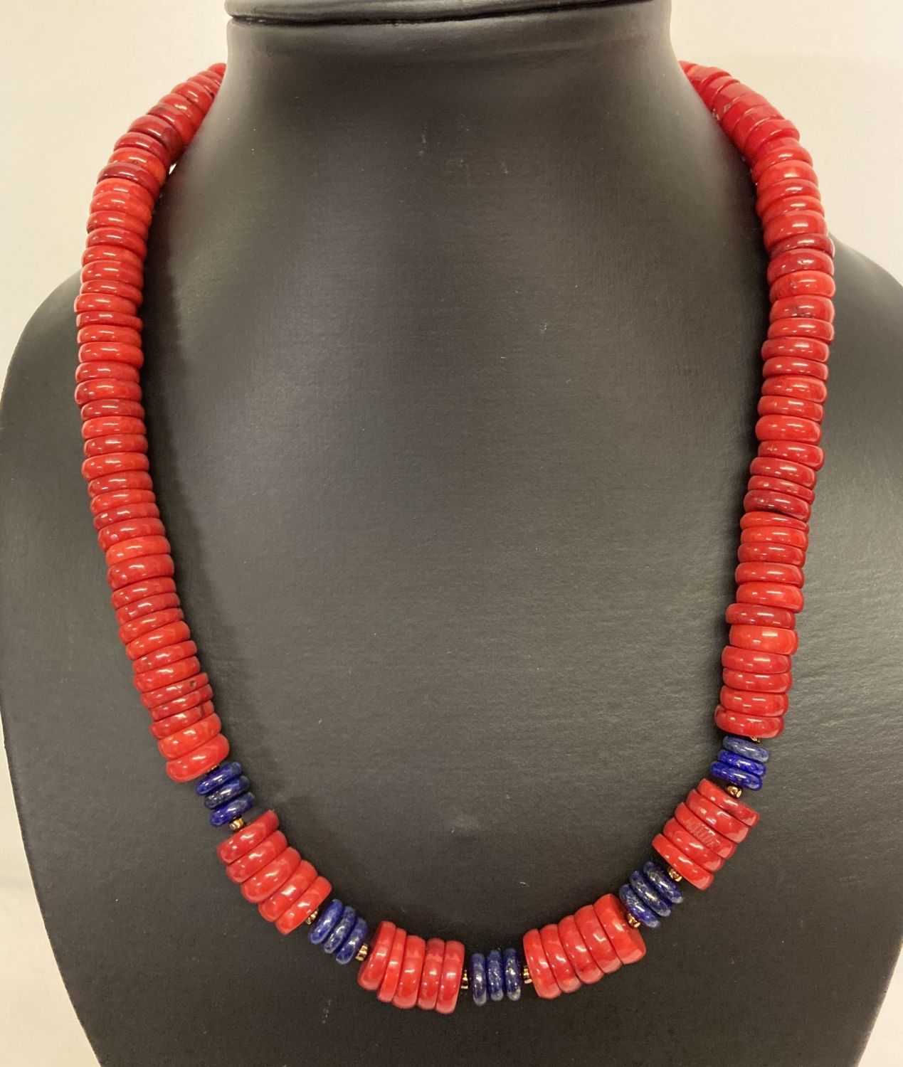 A 19" coral and lapis lazuli beaded necklace with circular shaped beads & gold tone S shaped clasp.