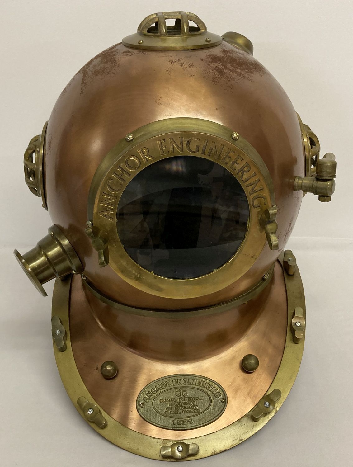 A copper and brass Anchor Engineering divers helmet with glass panels.