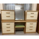 A 1980's light wood and cream dressing table and matching mirror and bedside cabinets.