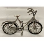A small 925 silver bicycle with rubber tyres and movable handle bars and front wheel.