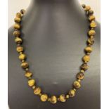A 19" Tiger's Eye beaded necklace with white metal T bar clasp.