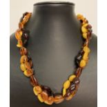A modern design, tri colour amber bead necklace with silver lobster style clasp and extension chain.