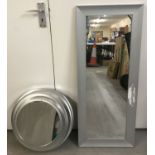 A modern silver tone framed port hole style wall mirror.