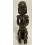 A hollow bronze tribal style figurine with indistinct signature mark to back.