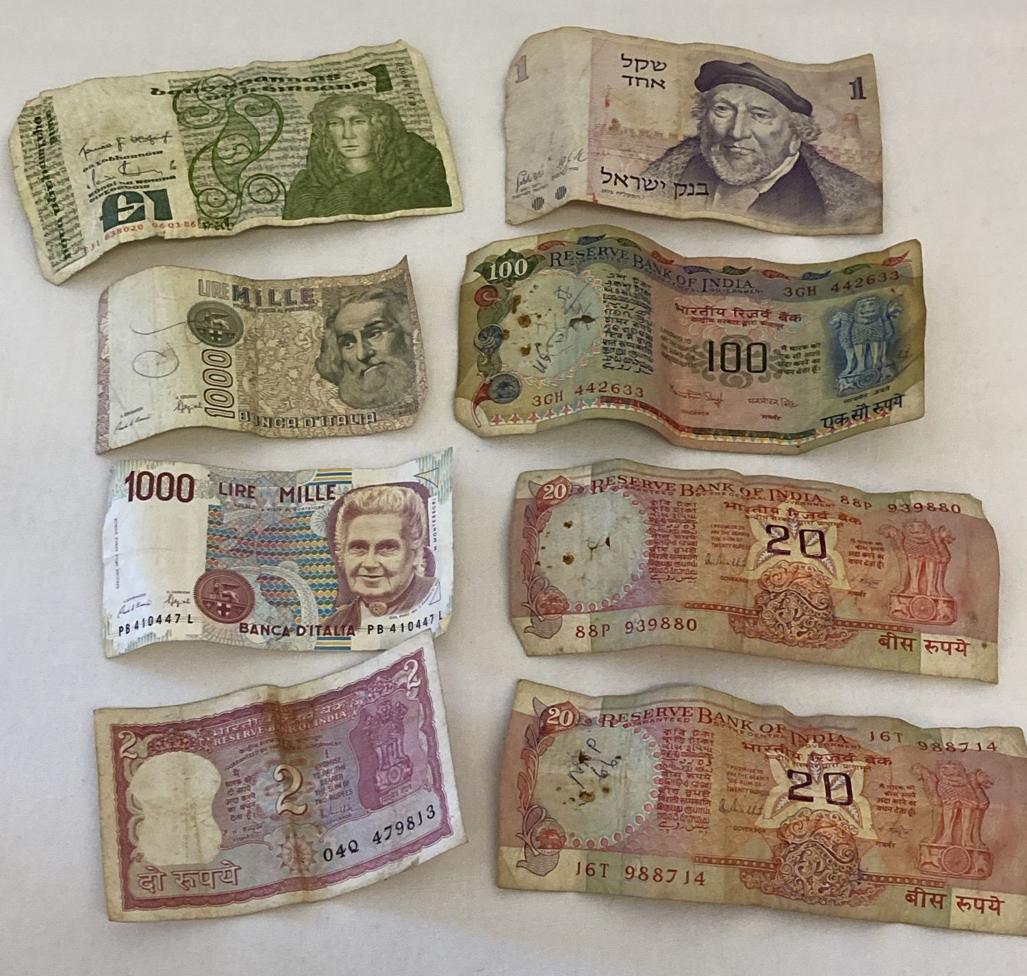 A collection of 8 vintage foreign bank notes from India, Israel, Ireland and Italy.