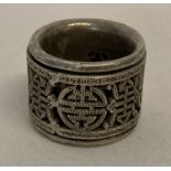 A Chinese white metal Archers ring with central rotating panel decorated with shou characters.