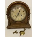 A vintage oak cased 8 day striking mantle clock with barley twist column detail.