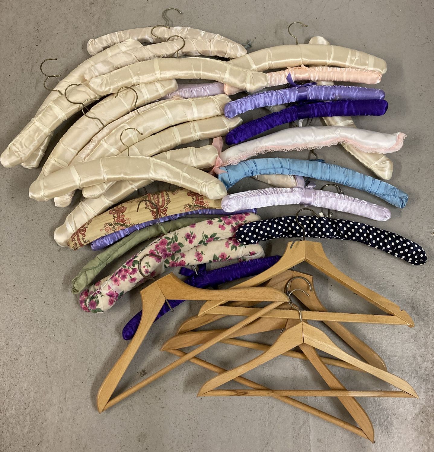 A collection of vintage wooden and padded coat hangers. To include floral designs.