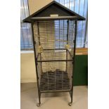 A large metal framed bird cage on castors, complete with cover and interior rails and troughs.