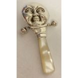 A silver moon face baby's rattle with pearl handle and 2 suspended bells.