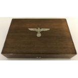 A WWII style Large wooden cigar box with metal Nazi eagle and swastika insignia attached to lid.