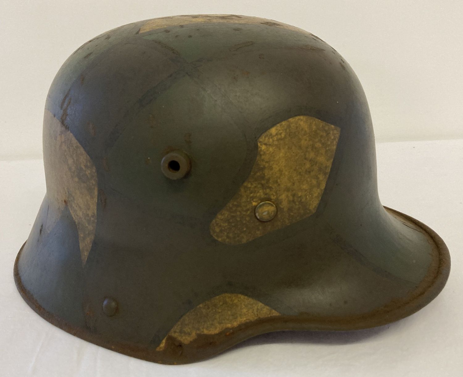 A German WWI style M16 stalhelm helmet with painted camouflage design, complete with leather liner.