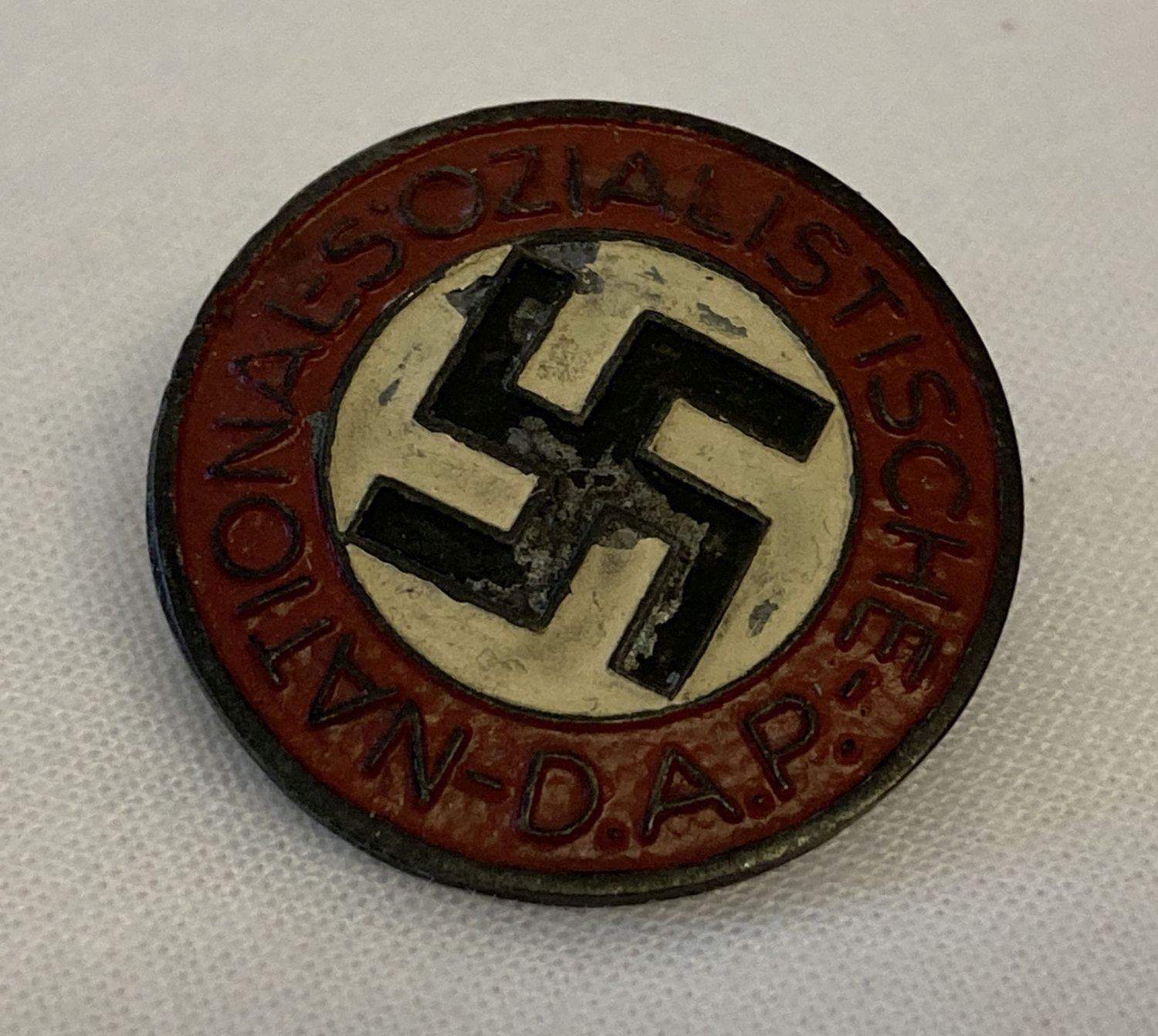 A German WWII style ersatz (economy issue) N.S.D.A.P. pin back badge.