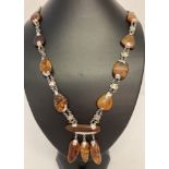 A modern design amber and silver necklace with fixed drop style pendant.