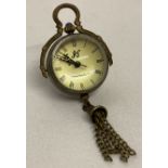 A brass bound ball watch pendant with tassel detail, roman numeral markers & hinged pendant bale.