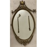 An ornamental vintage gilt framed wall mirror with swag and bow detail.