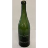 A green glass wine bottle with German WWII style engraved detail.