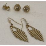 3 pairs of gold earrings in stud and drop styles.