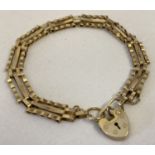 A 9ct gold 3 bar bracelet with padlock and safety chain.