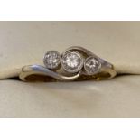 A vintage 18ct and platinum gold twist design bezel set diamond trilogy ring.