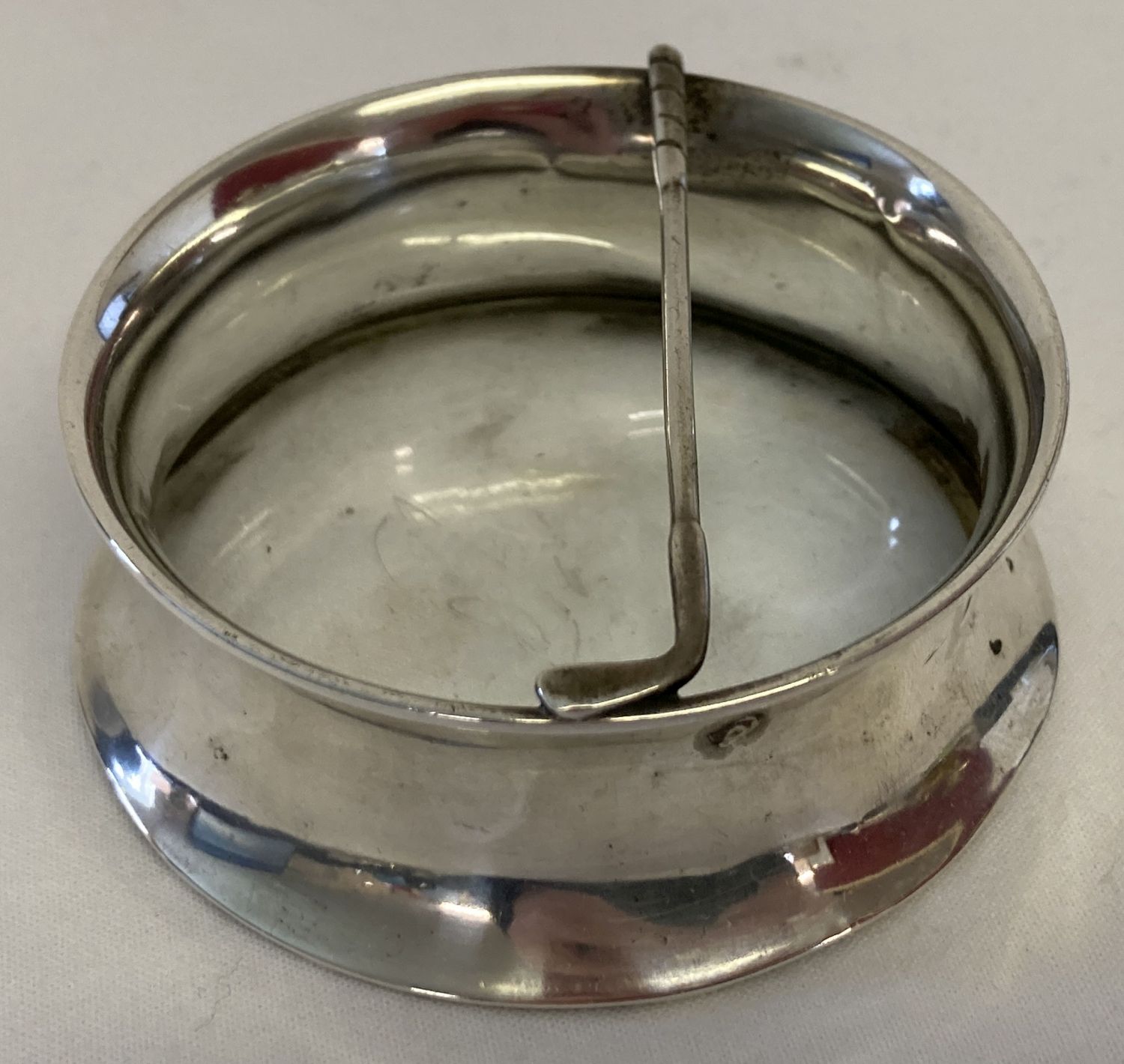 A glass bottom silver trinket/pin dish with golf club detail.