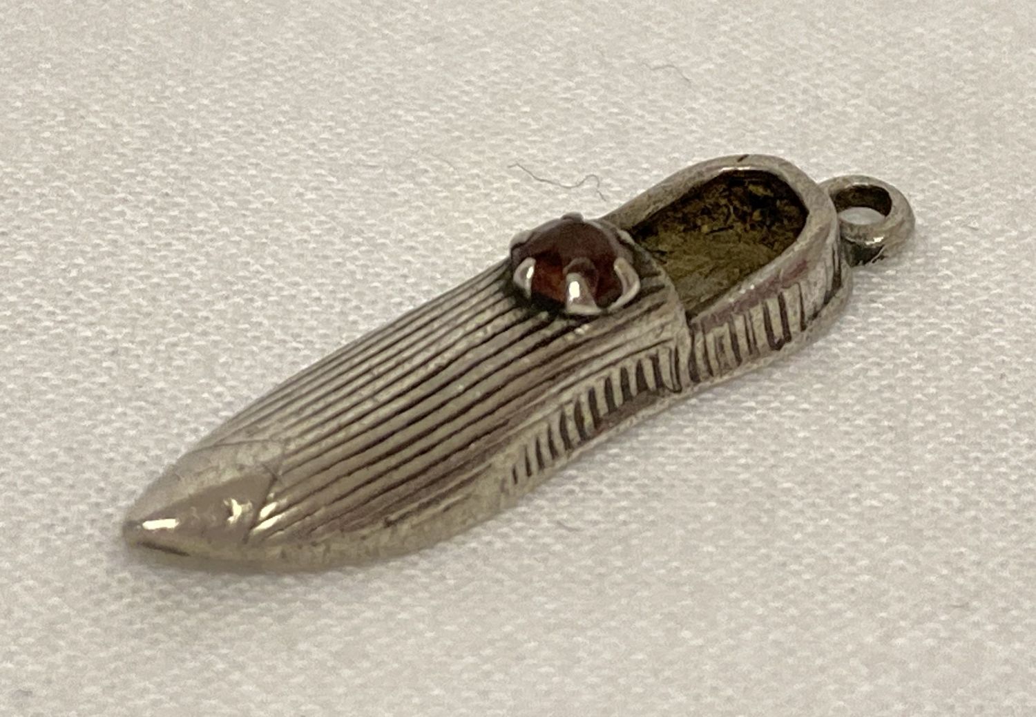 A small Charles Horner antique silver charm in the shape of a shoe set with a pink coloured stone.