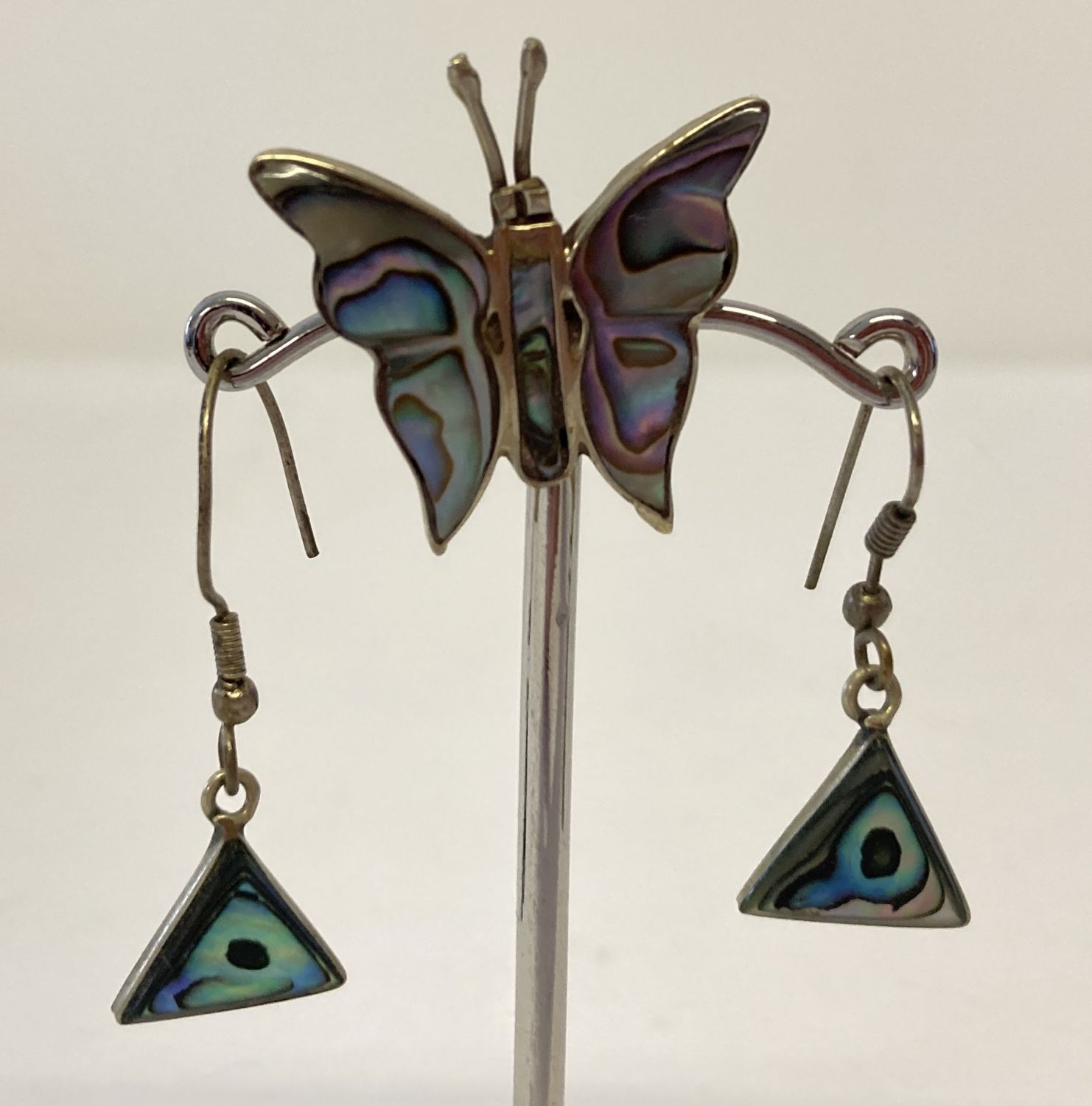 A Mexican silver butterfly brooch together with a pair of drop earrings, both set with paua shell.