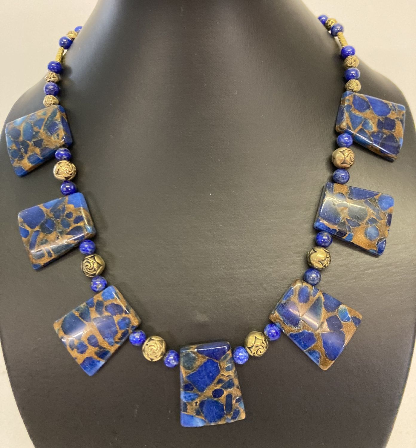 A boxed lapis Lazuli and gold tone bead Cleopatra style necklace with gold tone S shaped clasp.