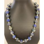 An alternating lapis lazuli and fresh water pearl 20" necklace, with silver tone T bar clasp.
