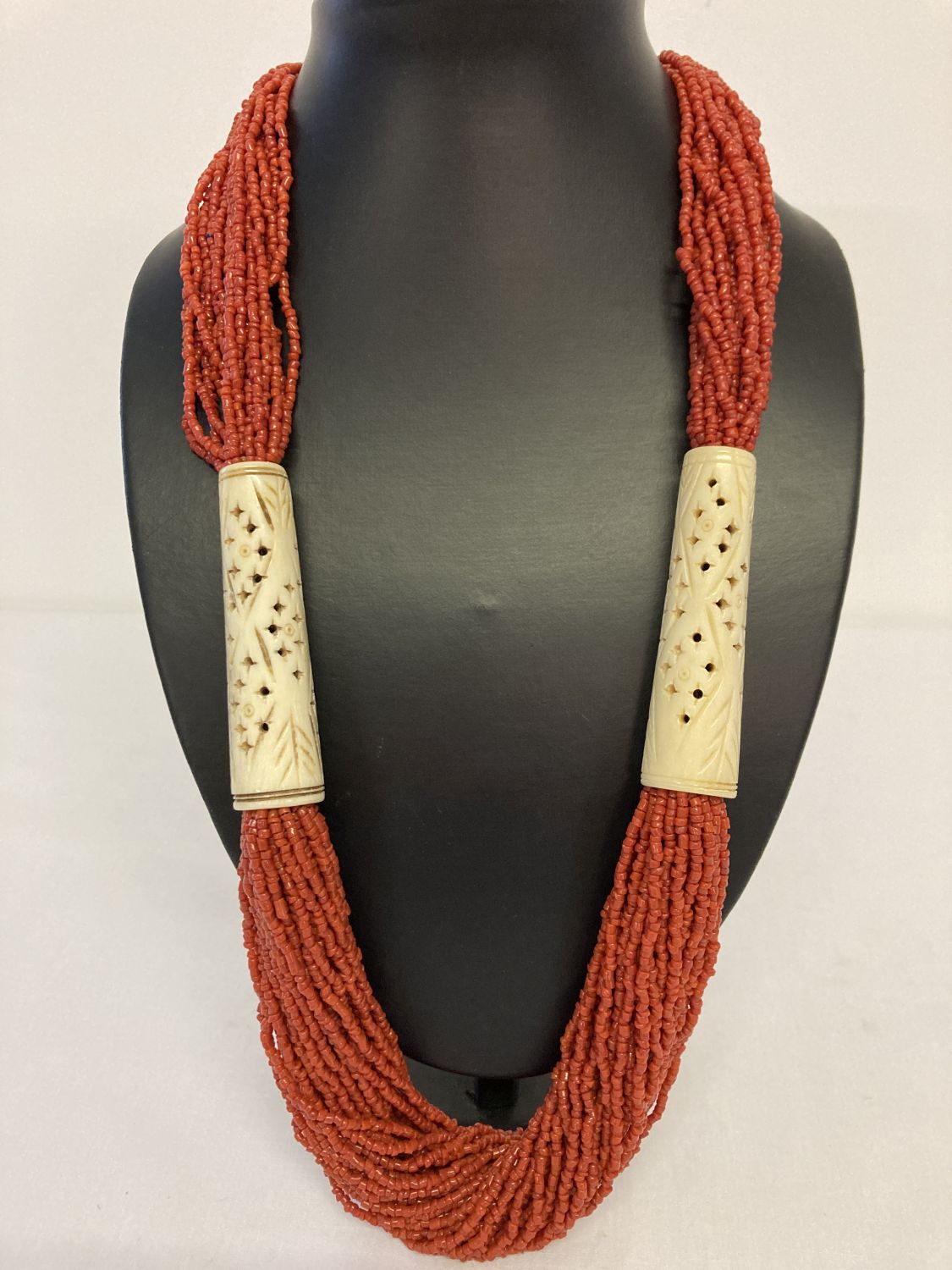 A large coral and natural bone statement necklace with button clasp.