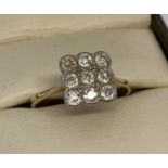 An 18ct gold and diamond dress ring in square design, set with 9 round cut diamonds.