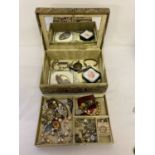 A gold fabric beaded jewellery box containing a collection of costume jewellery.