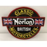 A painted cast iron Norton Motorcycles wall plaque with fixing holes.