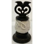 A black painted cast iron decorative string dispenser by Victor R Welch.