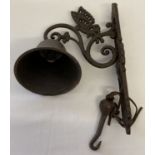 A cast metal wall hanging garden bell, with butterfly detail.